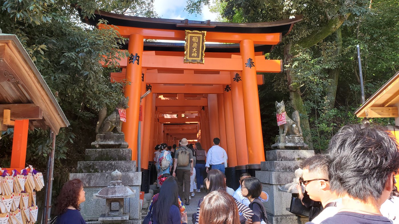 伏見稲荷大社に連なる朱色の鳥居と参拝客